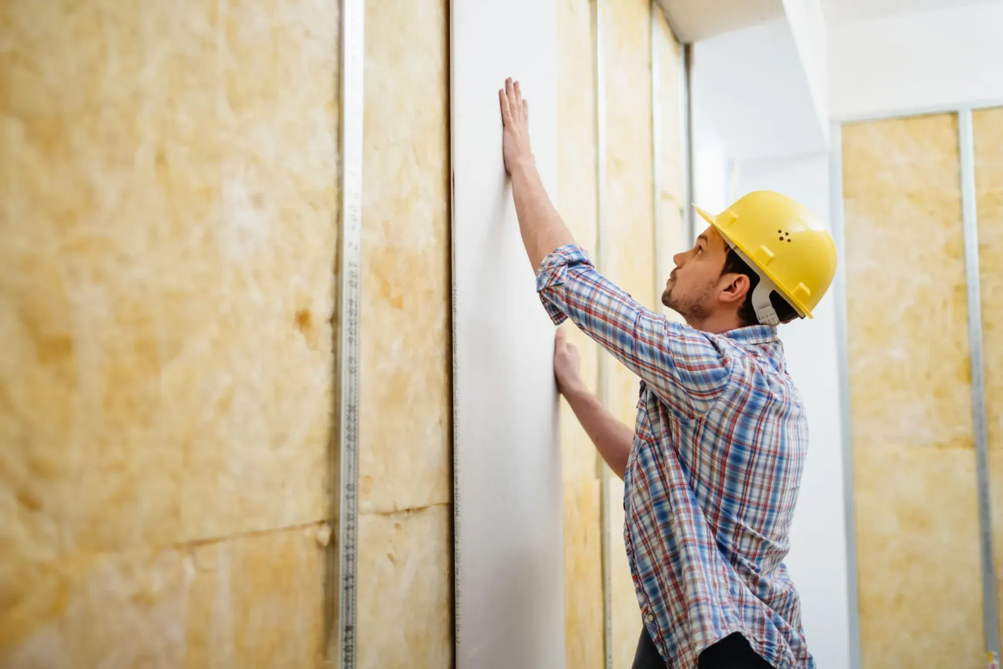 Instalação de placa de drywall com lã de vidro aparente entre os perfis
